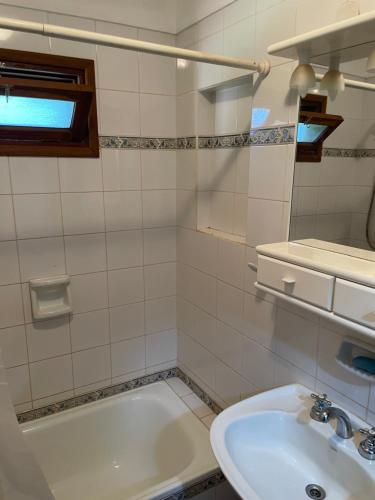 un baño con lavabo y bañera en Cabañas lodge El Suizo, en Gobernador Virasora