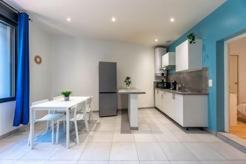 a kitchen with a table and a white table and chairs at L'appart du Général in Elbeuf