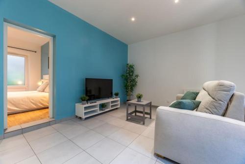 a living room with a couch and a television at L'appart du Général in Elbeuf