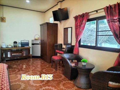 a living room with a couch and a table and a desk at Beach Home Lanta in Ko Lanta
