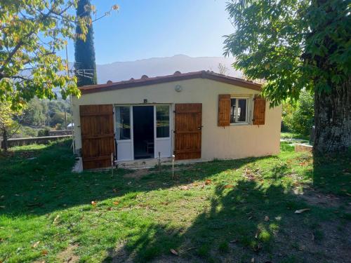 a small house in a yard with a tree at Maisonnette in Albertacce