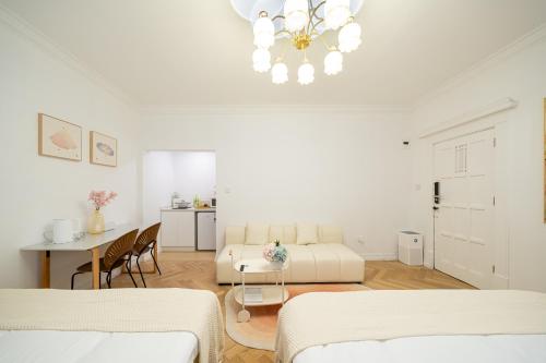 a white living room with a couch and a table at Tonight Homestay West Nanjing Road Shanghai in Shanghai
