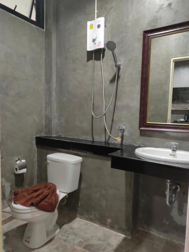 a bathroom with a toilet and a sink at Phudis Guest House in Ban Khlong Haeng