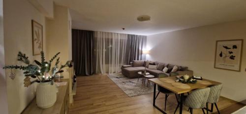 a living room with a couch and a table at Free SPA Pirin lodge cosy apartment in Bansko