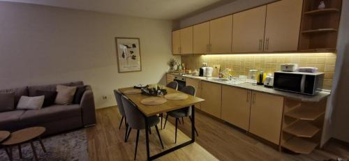 a kitchen and a living room with a table and a couch at Free SPA Pirin lodge cosy apartment in Bansko