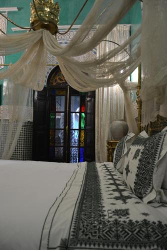 a bedroom with a bed with a canopy at Palais AL Firdaous in Fès