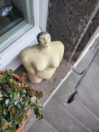 a statue sitting next to a window next to a potted plant at Hotel Restaurant Alte Stadtmauer in Beilstein