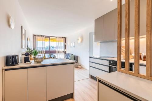 une cuisine avec des armoires blanches et un comptoir dans l'établissement Superbe T2 centre Montpellier, à Montpellier