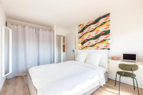 une chambre blanche avec un lit blanc et un bureau dans l'établissement Superbe T2 centre Montpellier, à Montpellier