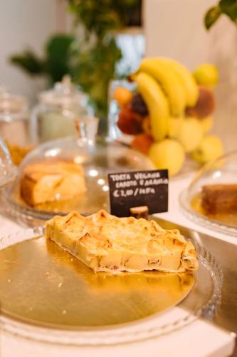 a pie on a plate on a table with bananas at Tomato Urban Retreat in Turin