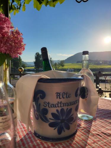 a table with two bottles of wine and a cup at Hotel Restaurant Alte Stadtmauer in Beilstein