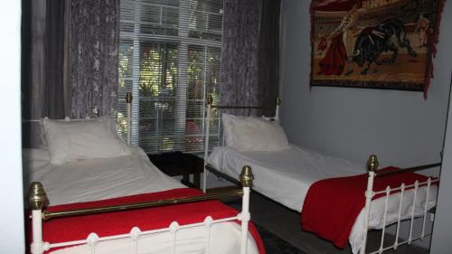 two twin beds in a room with a window at Eagle's Nest in Barberton