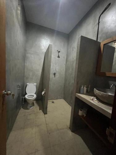 a bathroom with a toilet and a sink at Keramas temuku family Guest house in Gianyar