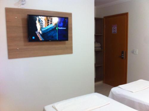 a room with a tv on a wall at Di Napoli Plaza Hotel in Gurupi