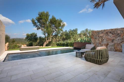 a swimming pool in a yard with a couch and a chair at Stazzo Lu Ciaccaru in Arzachena