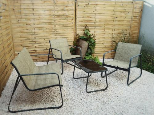 un groupe de trois chaises et d'une table sur une terrasse dans l'établissement Tiny house avec terrasse privée, à Mulhouse