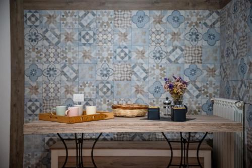a table with candles and flowers on a tiled wall at Madì Rooms in Naples