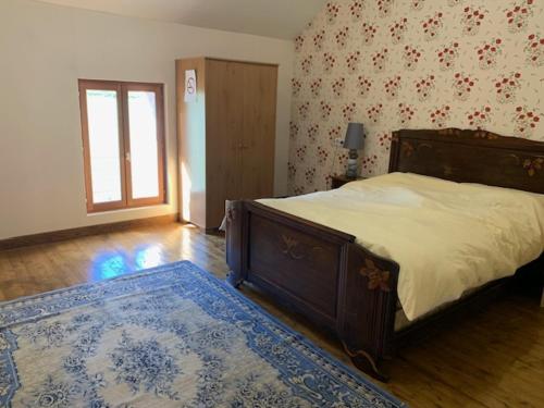 una camera con un grande letto e un tappeto blu di Maison Lushbrooks a Moutier-Malcard