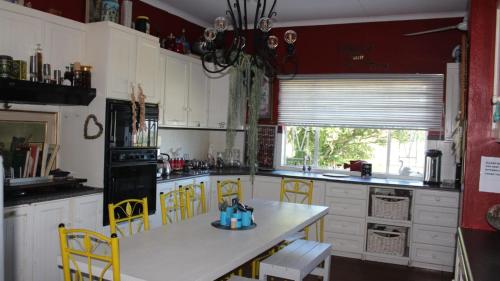 a kitchen with yellow chairs and a white counter top at Eagle's Nest in Barberton
