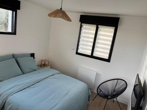 ein Schlafzimmer mit einem blauen Bett und einem Fenster in der Unterkunft La Vallée des Biches G1 in Saint-Martin-Boulogne