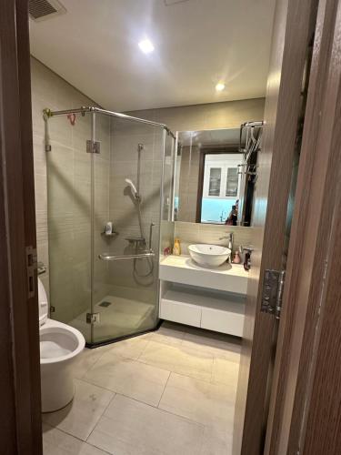 a bathroom with a shower and a toilet and a sink at QM House 08 in Hanoi
