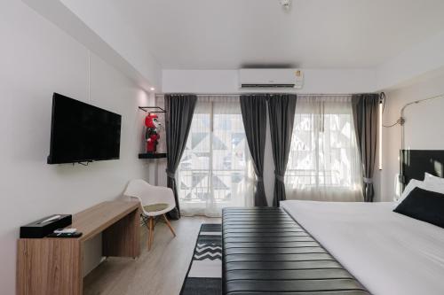 チェンマイにあるThe Core Gallery Hotelのベッドルーム(ベッド1台、デスク、テレビ付)