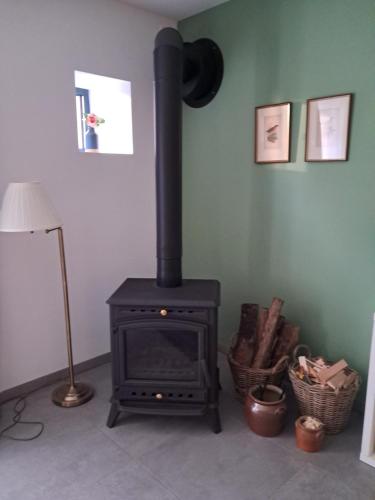 a black stove in a room with a lamp at Stable Cottage at Le Prieuré in Mantilly