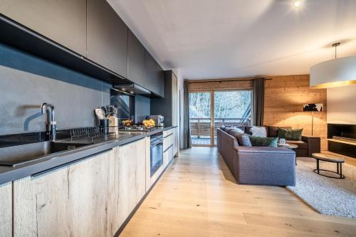 une cuisine et un salon avec un canapé dans l'établissement Maira Les Carroz - by EMERALD STAY, à Arâches-la-Frasse