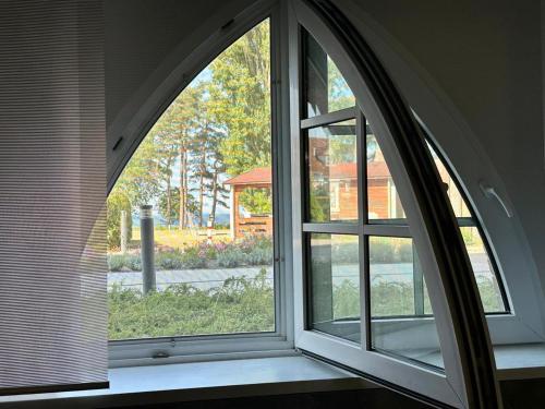 an arched window with a view of a garden at Residence Black Eagle Lubmin Strand in Lubmin
