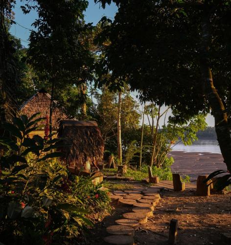a garden with a stone path leading to a house at Ecolucerna Lodge Tambopata in Puerto Maldonado