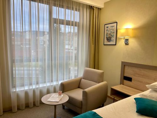 a hotel room with a chair and a window at Hotel Siesta in Užice