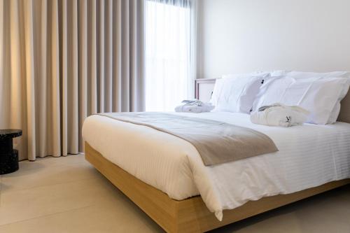 a bedroom with a bed with white sheets and pillows at M31Boutique Suites in Mellieħa