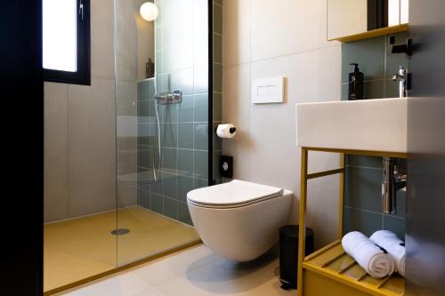 a bathroom with a toilet and a glass shower at M31Boutique Suites in Mellieħa