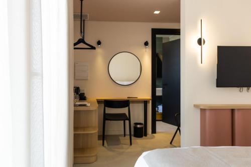a bedroom with a desk and a mirror on the wall at M31Boutique Suites in Mellieħa