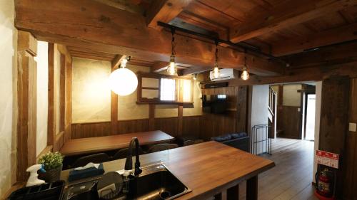 a kitchen with a sink and a wooden table at Kominka Hotel FUKUNOKURA 古民家ホテル ふくの蔵 #FR1 in Nishiaizu