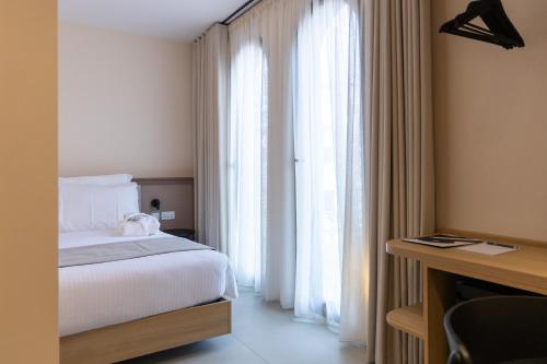 a bedroom with a bed and a large window at M31Boutique Suites in Mellieħa