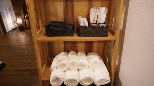 a wooden shelf with white towels and black baskets at Kominka Hotel FUKUNOKURA 古民家ホテル ふくの蔵 #FR1 in Nishiaizu