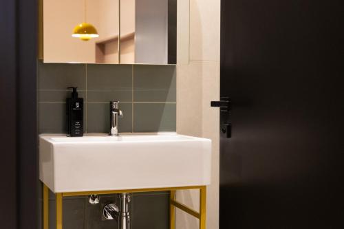 a bathroom with a white sink and a mirror at M31Boutique Suites in Mellieħa