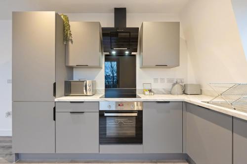 a kitchen with white cabinets and a microwave at Stylish Two Bedroom Apartment - Secure Parking & Balcony 9MC in Birmingham