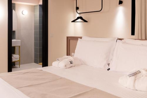 a bedroom with a white bed with towels on it at M31Boutique Suites in Mellieħa
