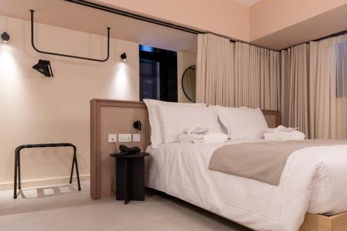 a bedroom with a large bed with white sheets at M31Boutique Suites in Mellieħa