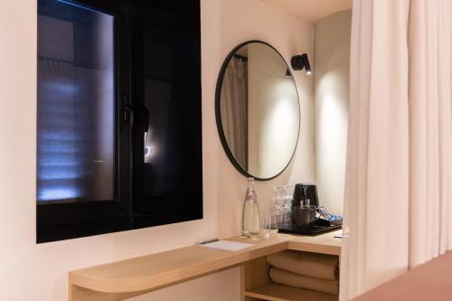 a bathroom with a mirror and a sink at M31Boutique Suites in Mellieħa