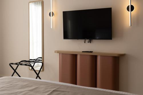 a bedroom with a flat screen tv on a wall at M31Boutique Suites in Mellieħa