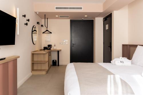 a bedroom with a white bed and a black door at M31Boutique Suites in Mellieħa
