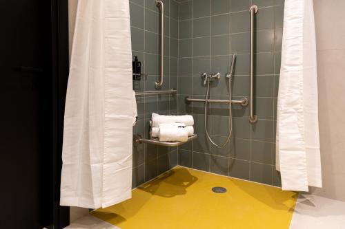 a bathroom with a shower with a yellow floor at M31Boutique Suites in Mellieħa