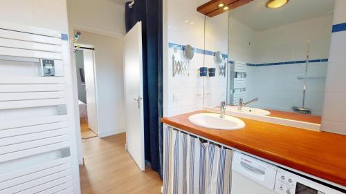 une salle de bain avec un lavabo et un miroir dans l'établissement La Perle de L Auzance, à Brem-sur-Mer