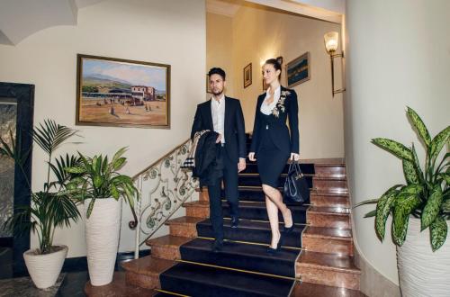 a man and a woman walking down the stairs at International au Lac Historic Lakeside Hotel in Lugano