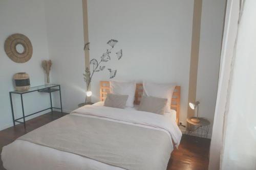 a bedroom with a large white bed with white sheets at Visiter et travailler près de Paris - Kalula in Clamart