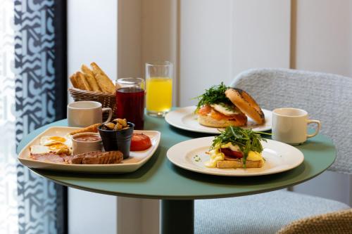 - une table avec deux assiettes de produits pour le petit-déjeuner et des boissons dans l'établissement M31Boutique Suites, à Mellieħa
