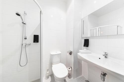 a bathroom with a shower and a toilet and a sink at TRIBE Riga City Centre in Rīga